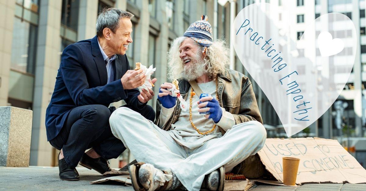 Business man sharing a sandwich and soda with a homeless gentleman